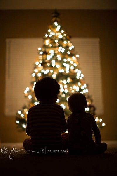 Com a árvore de Natal iluminando a silhueta dos filhos, essa foto é uma ótima ideia para cartão (Foto: Reprodução)